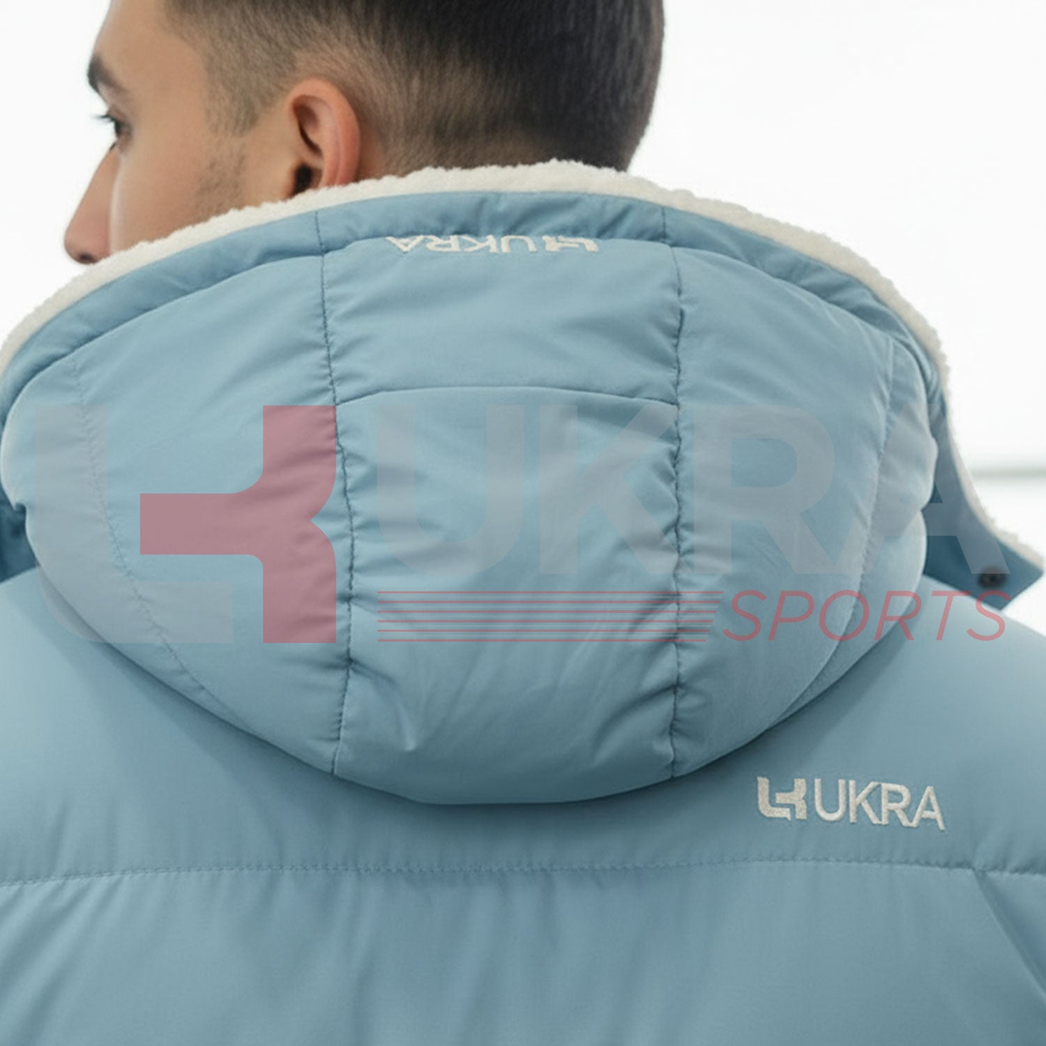 Close-upofUKRAembroideredlogoonhoodofbluepufferjacket.