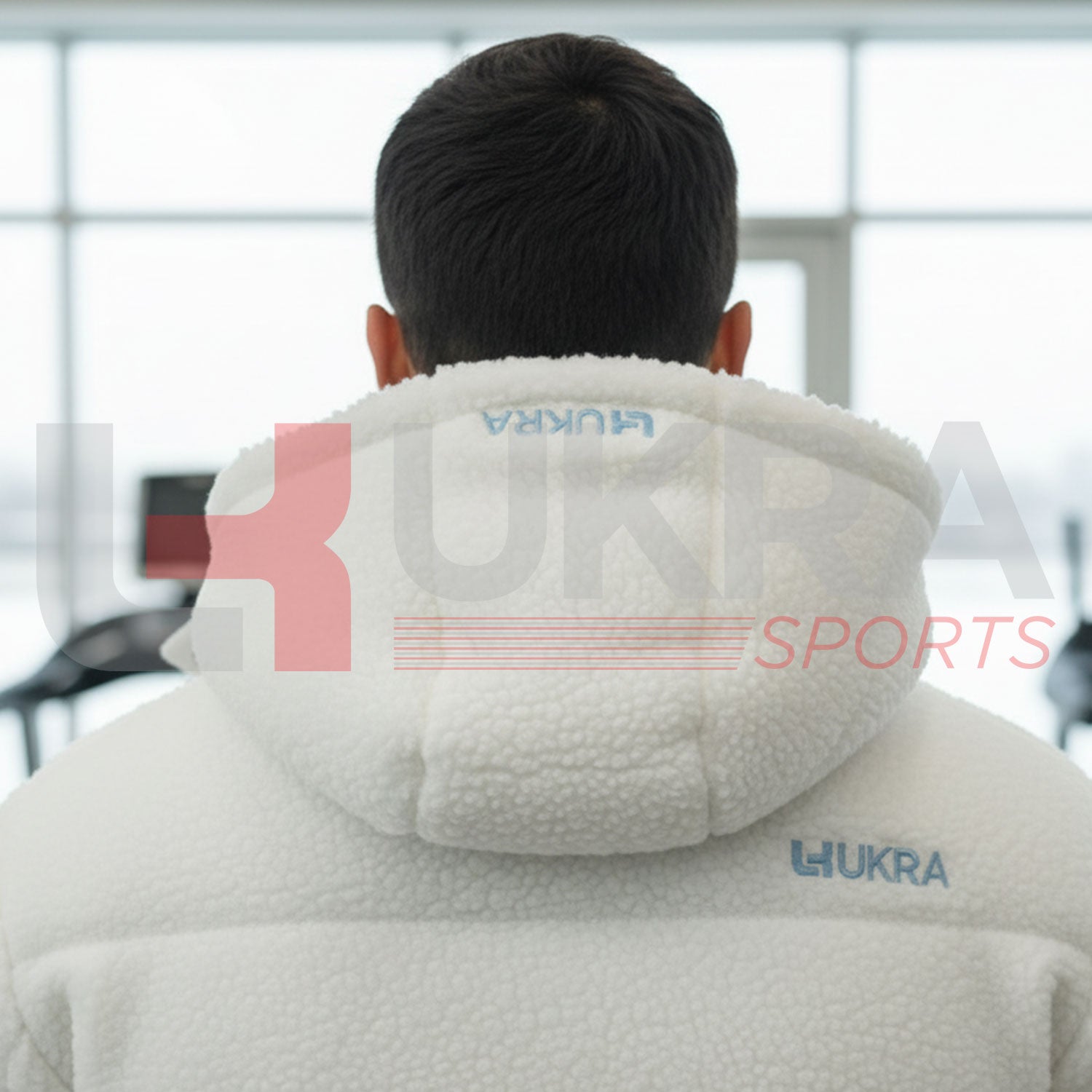 Close-upofUKRAembroideredlogoonhoodofwhitesheepjacket.