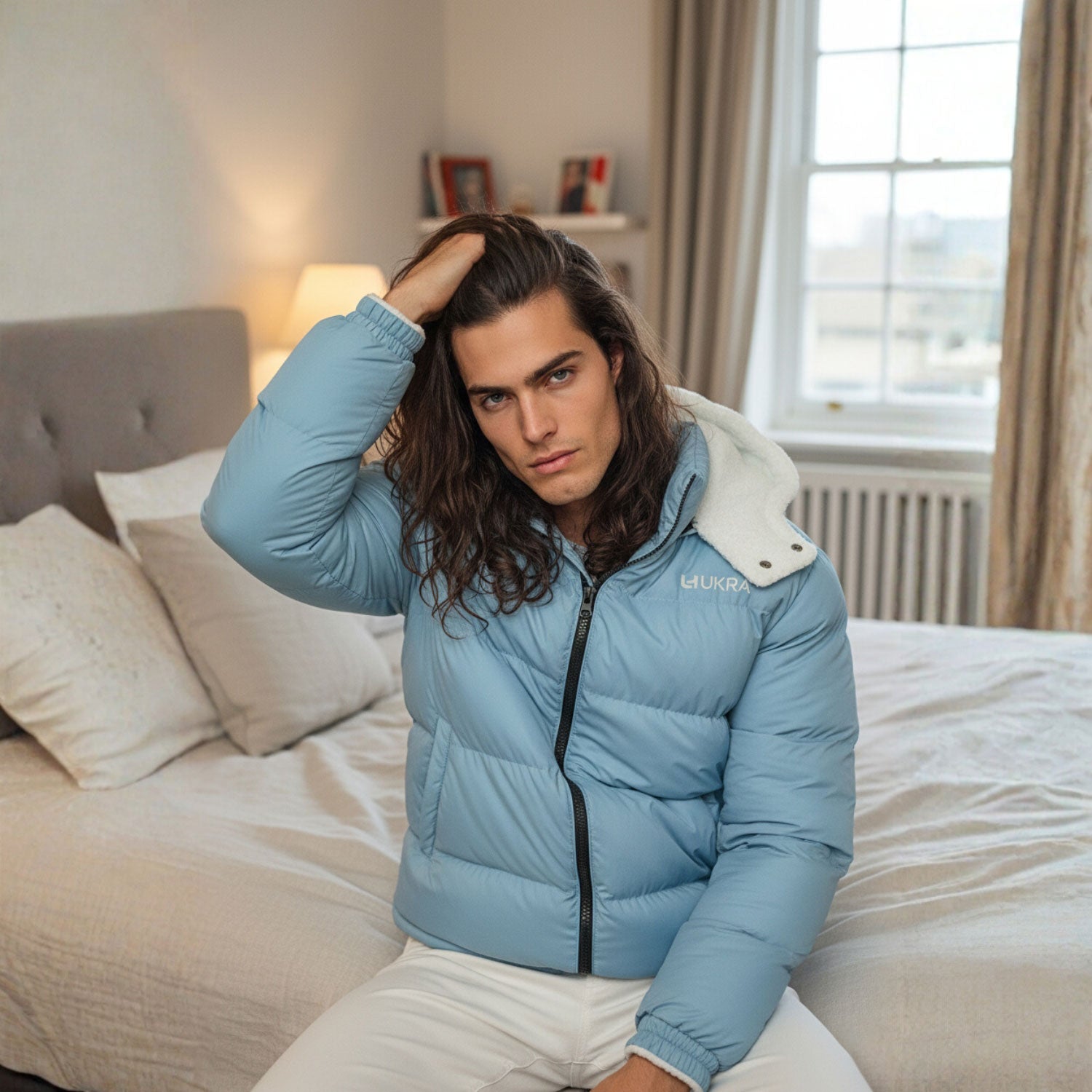 Lifestyle photo of UKRA blue puffer jacket in modern bedroom scene.